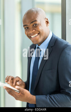 cheerful black businessman with tablet computer in modern office Stock Photo