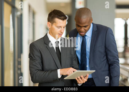 two businessmen using tablet computer in office Stock Photo