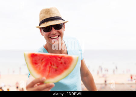 excited young man giving slice of watermelon Stock Photo