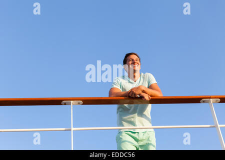 low angle view of happy man looking away on cruise ship Stock Photo