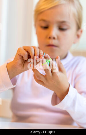 Little girl making bracelets with loomboard Stock Photo