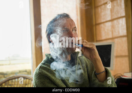 A man using an electronic cigarette, vaping. Stock Photo