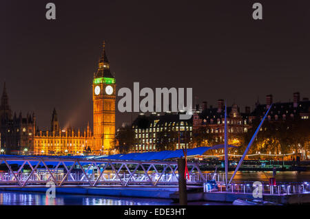 Big Ben and pier on River Thames in London at night Stock Photo