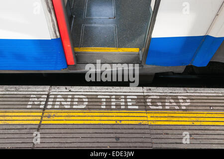 Closeup of mind the gap sign on a platform edge with open train door Stock Photo