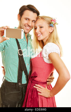 Happy couple taking selfie with smartphone in Bavaria Stock Photo