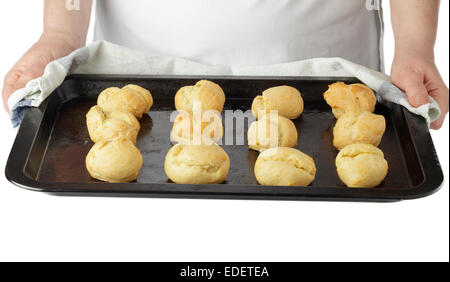 hands holding tray of choux pastry profiteroles Stock Photo