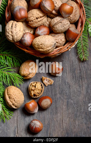 Walnuts and hazelnuts in  bowl isolated on old wooden background Stock Photo