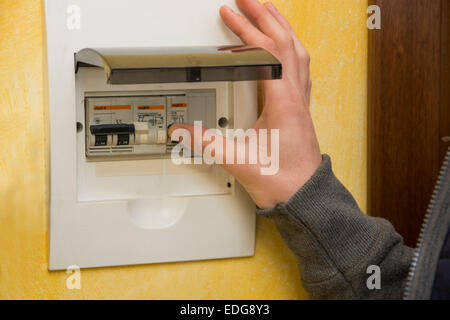 Close up of male hand using an electronic control panel, to switch on electricity at home Stock Photo