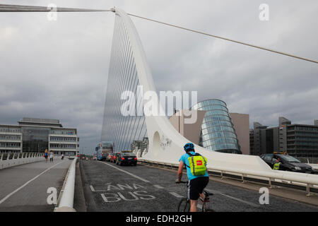 biker on Samuel Beckett Bridge crossing the River Liffey and the Convention Centre on Spencer Dock in Dublin
