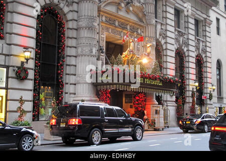 The front entrance to the Peninsula hotel at Christmas decorated with trees, lights and reindeer Stock Photo