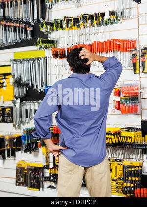 Confused Customer Scratching Head In Hardware Shop Stock Photo