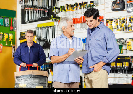 Customers Checking Checklist In Hardware Store Stock Photo