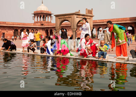 Devout Muslims purifying themselves in the water basin of the Friday Mosque Jama Masjid, Delhi, India Stock Photo