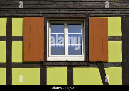 Green timberframe house - Window with wooden shutters Exterior green painted  timbered house in the Alsace, France Stock Photo