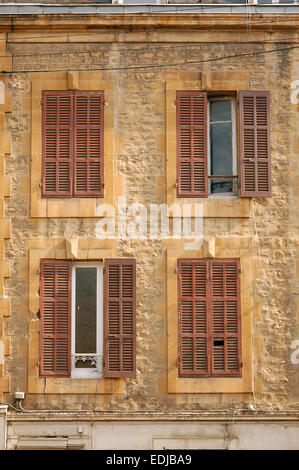 Facade of a building with 4 windows with closed or half open window shutters in Sedan, France Stock Photo