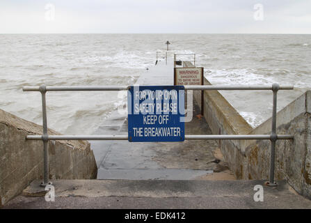 Safety sign and warning sign on breakwater with rough sea, Walton-on-the-Naze, Essex Stock Photo