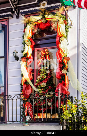 Christmas decorations hang around the window of a house in New Orleans LA Stock Photo