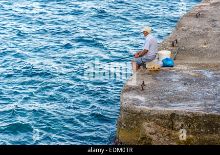 Old man fishing in Crete, Greece Stock Photo