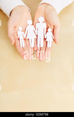 Two female hands holding a paper family sillhouette Stock Photo