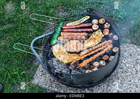 Meat cooking on small barbecue grill Stock Photo