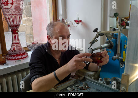 Christal glass cutter at work decorating wine glasses in a shop at Prague Castle Stock Photo