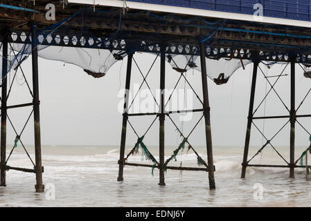 The Victorian iron struts and legs of Eastbourne Pier, a grade II* listed building and netting added after the fire in Sept 2014 Stock Photo