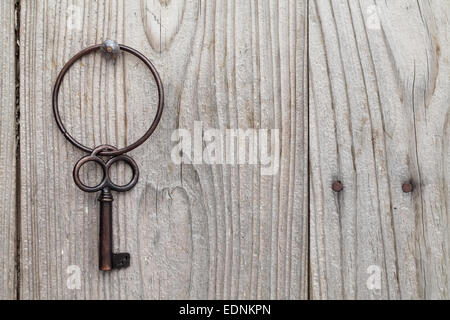 rusty keys and keyring hanging on a wooden background Stock Photo