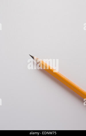 Yellow pencil on a white paper background Stock Photo