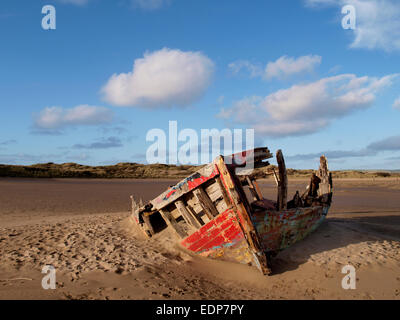 Old wooden boat decaying in the sand on the edge of the River Taw on the edge of Braunton Burrows, Devon, UK Stock Photo