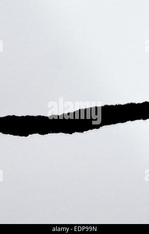 White paper with torn edges with a black isolated background inside ...