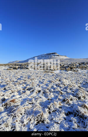 Limestone pavement below a snowy Pen-y-ghent on the Pennine Way, Yorkshire Dales National Park, North Yorkshire, England, UK. Stock Photo