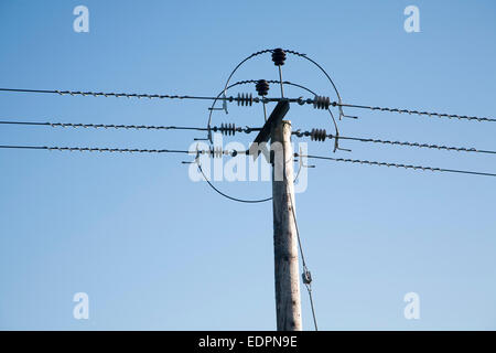 Close up of electricity cables and telegraph pole against blue sky, UK Stock Photo
