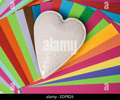 White metal heart on a colorful papers. Valentine's Day. Stock Photo