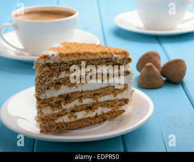 piece of cake on blue wooden table in the background cup of coffee and chocolate truffles Stock Photo