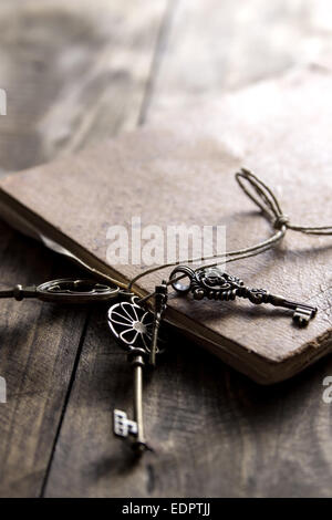 old book and a brass key on a vintage surface, close up Stock Photo