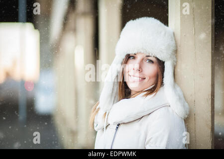 Girl in white hat and warm jacket in winter cold Stock Photo