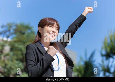 Happy Businesswoman with One Arm up and Another One Making Fist Stock Photo
