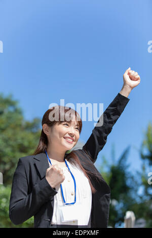 Happy Businesswoman with One Arm up and Another One Making Fist Stock Photo