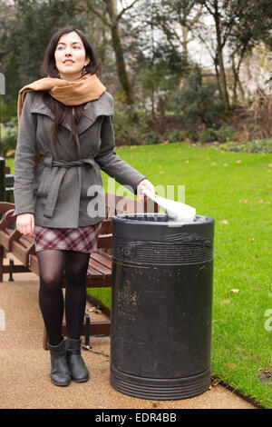 young woman throwing rubbish in the bin Stock Photo