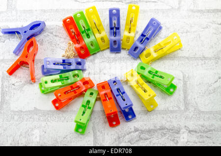 Bunch of colorful clothespins on a white wall Stock Photo