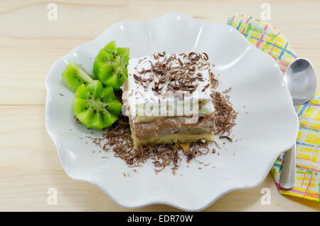 A slice of cake with kiwi garnish on a plate Stock Photo