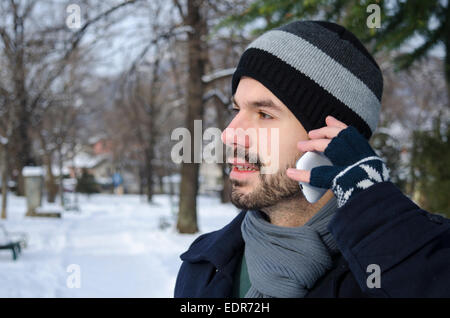 Bearded man talking on a cell phone in winter Stock Photo