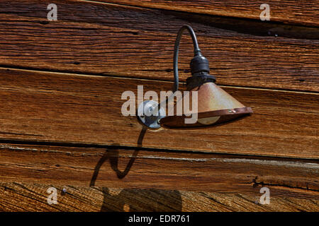 Old electric lamp on a wooden wall Stock Photo