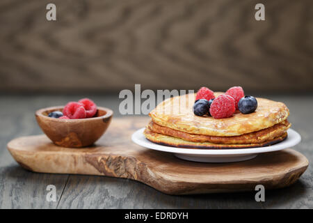 Pancakes with raspberry, blueberry, on oak wooden table Stock Photo