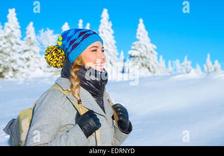 Portrait of happy cute girl traveling along snowy mountains, enjoying wintertime nature, active lifestyle, winter vacation Stock Photo
