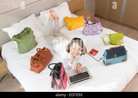 Young woman using laptop with handbags around Stock Photo