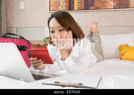 Young woman using laptop with handbags around Stock Photo