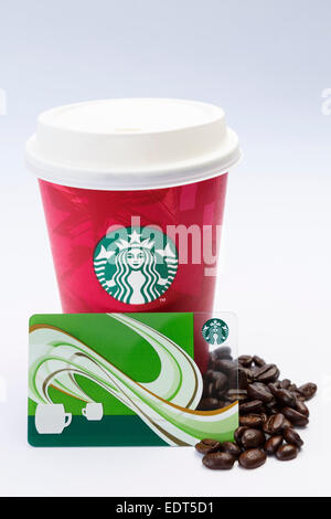Starbucks disposable take-away paper coffee cup with plastic drink-through lid, loyalty points card and fresh coffee beans on plain background. UK Stock Photo