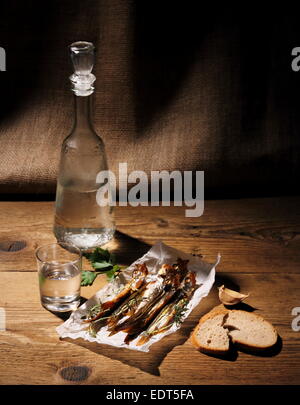 Glass of vodka with dried capelin and bread, vertical Stock Photo