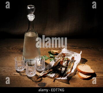 Three glass for vodka with dried capelin and bread, still life Stock Photo